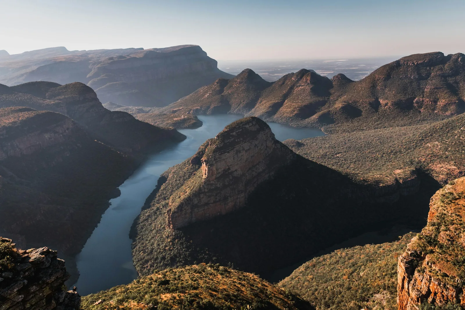 The river winds between steep, sunlit cliffs in Blyde River Canyon, Mpumalanga.
